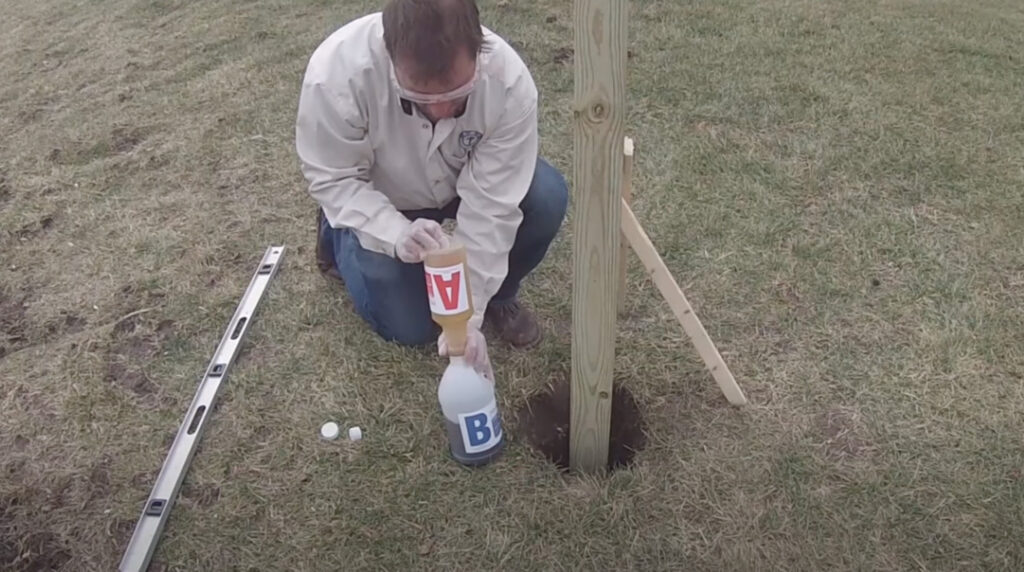 Fence installer pours bottle A into bottle B to create the postloc product for installing fence posts